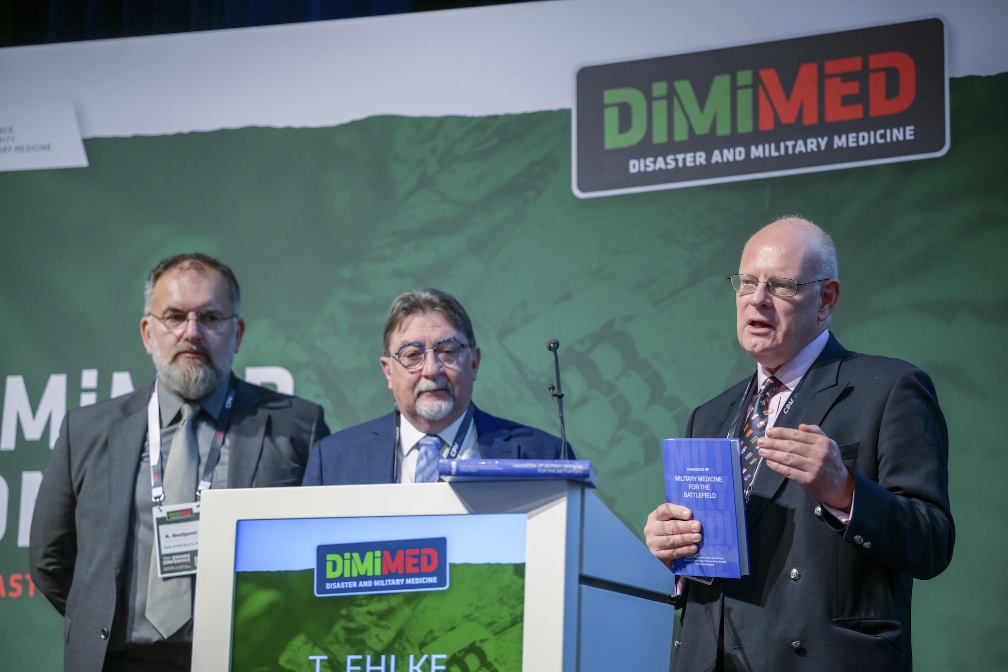 Vorstellung des im CPM Verlag erschienenen "Handbook of Military Medicine for the Battlefield" auf der DiMiMED durch die Autoren (v. l. n. r.): Aleksandar Smiljanic, Brigadegeneral a. D. Dr. Joachim Hoitz und Generalleutnant a. D. Prof. Martin Bricknell.