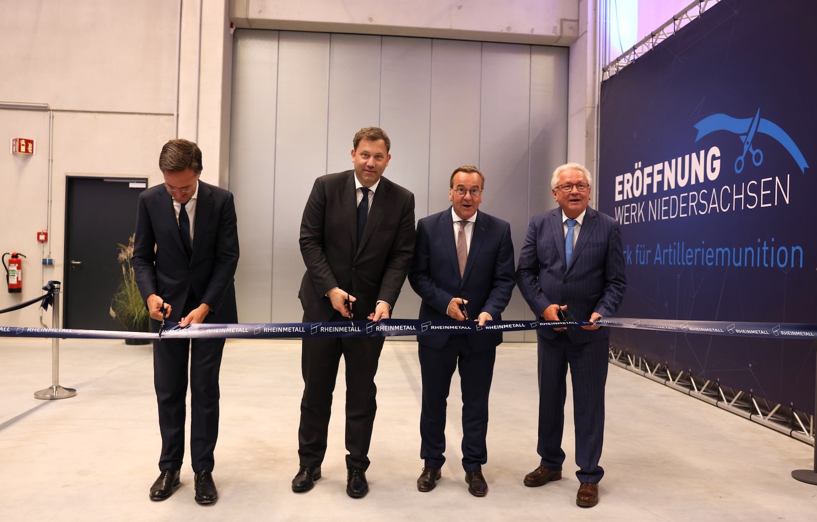 Zerschneiden das blaue Band zur Eröffnung der neuen Munitionsfabrik von Rheinmetall in Unterlüß (v. l. n.r.): NATO.Generalsekretär Mark Rutte, Finanzminister Lars Klingbeil, Verteidigungsminister Boris Pistorius und Rheinmetall-Chef Armin Papperger.
