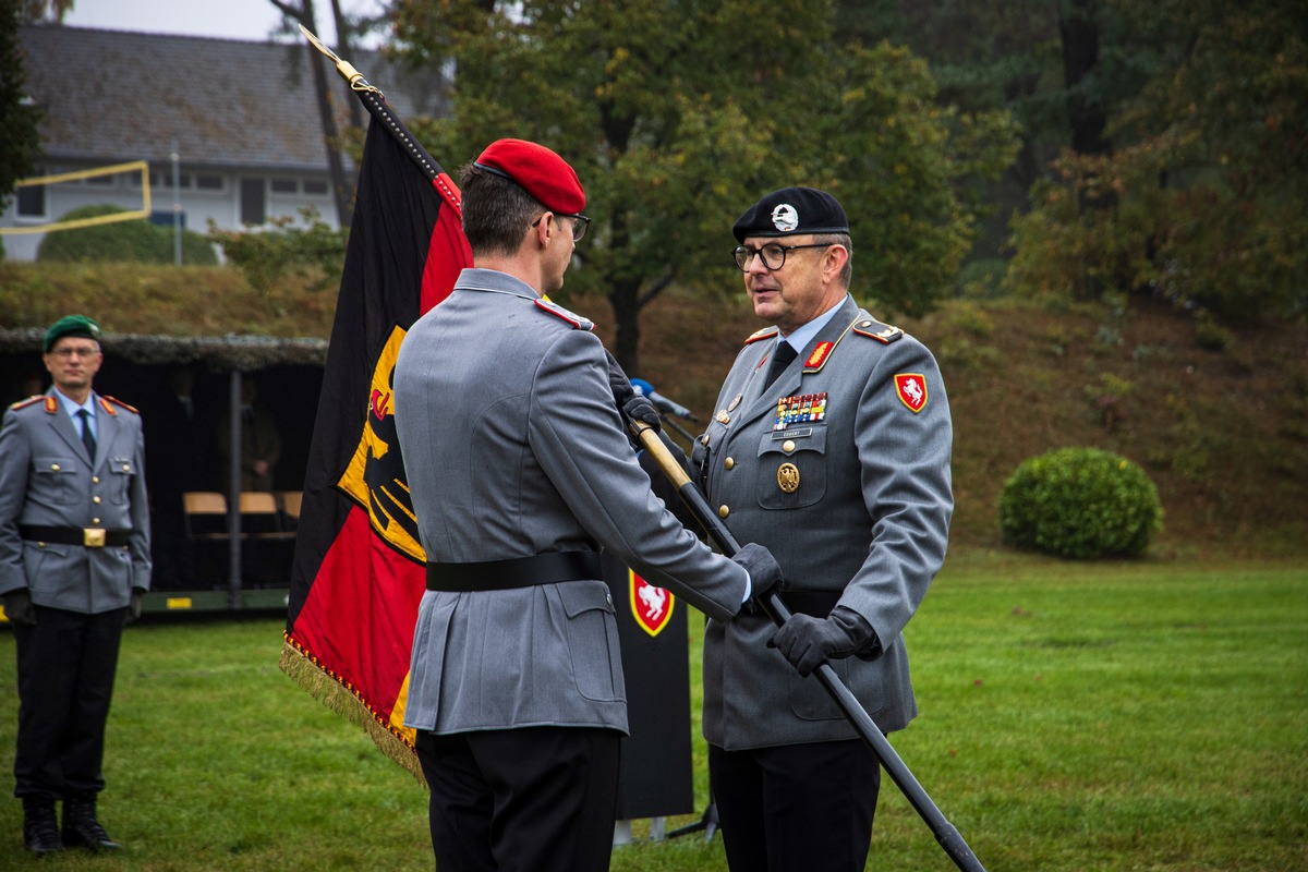 Der Kommandeur der Panzerbrigade 21, Brigadegeneral Marco Eggert, übergibt die Truppenfahne an den neuen Kommandeur des Artilleriebataillons 215, Oberstleutnant Fabian Kolbe. Die Truppenfahne steht sinnbildlich für die Soldatinnen und Soldaten einer Bundeswehreinheit.