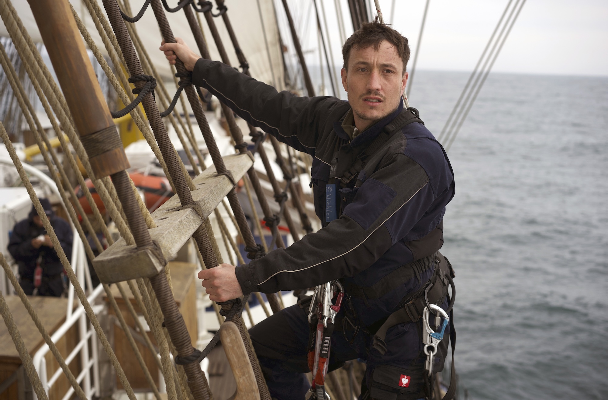 Y-Kollektiv-Redakteur Lukas Wiehler in der Takelage der „Gorch Fock“. Für seine Reportage wurde er Teil der Crew und segelte zwei Wochen lang mit, von den Azoren bis auf die schottischen Shetland-Inseln.