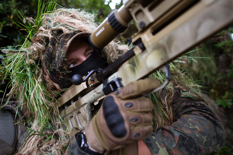 Ein KSK-Soldat der Bundeswehr bei der Scharfschützenausbildung interessiert sich auch für das KSK Symposium..