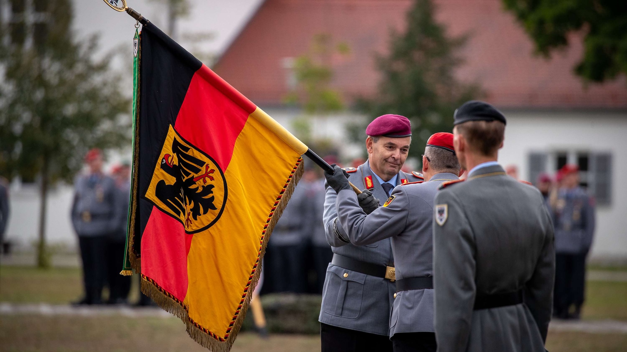 Der scheidende Inspekteur des Heeres, Generalleutnant Alfons Mais (r.) überreicht die Truppenfahne des Kommandos Heer an den Generalinspekteur der Bundeswehr, General Carsten Breuer. Das besiegelt symbolisch die Entbindung vom Kommando.