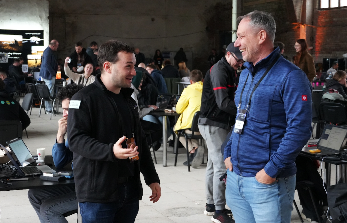 Dr. Benjamin Wolba (Co-Founder des EDTH, links im Bild) im Gespräch mit Florian Dötzer (Managing Director des Venture Labs für Aerospace & Defense der Technischen Universität München) während des Hackathons in Lviv, Foto: Connor Rehn