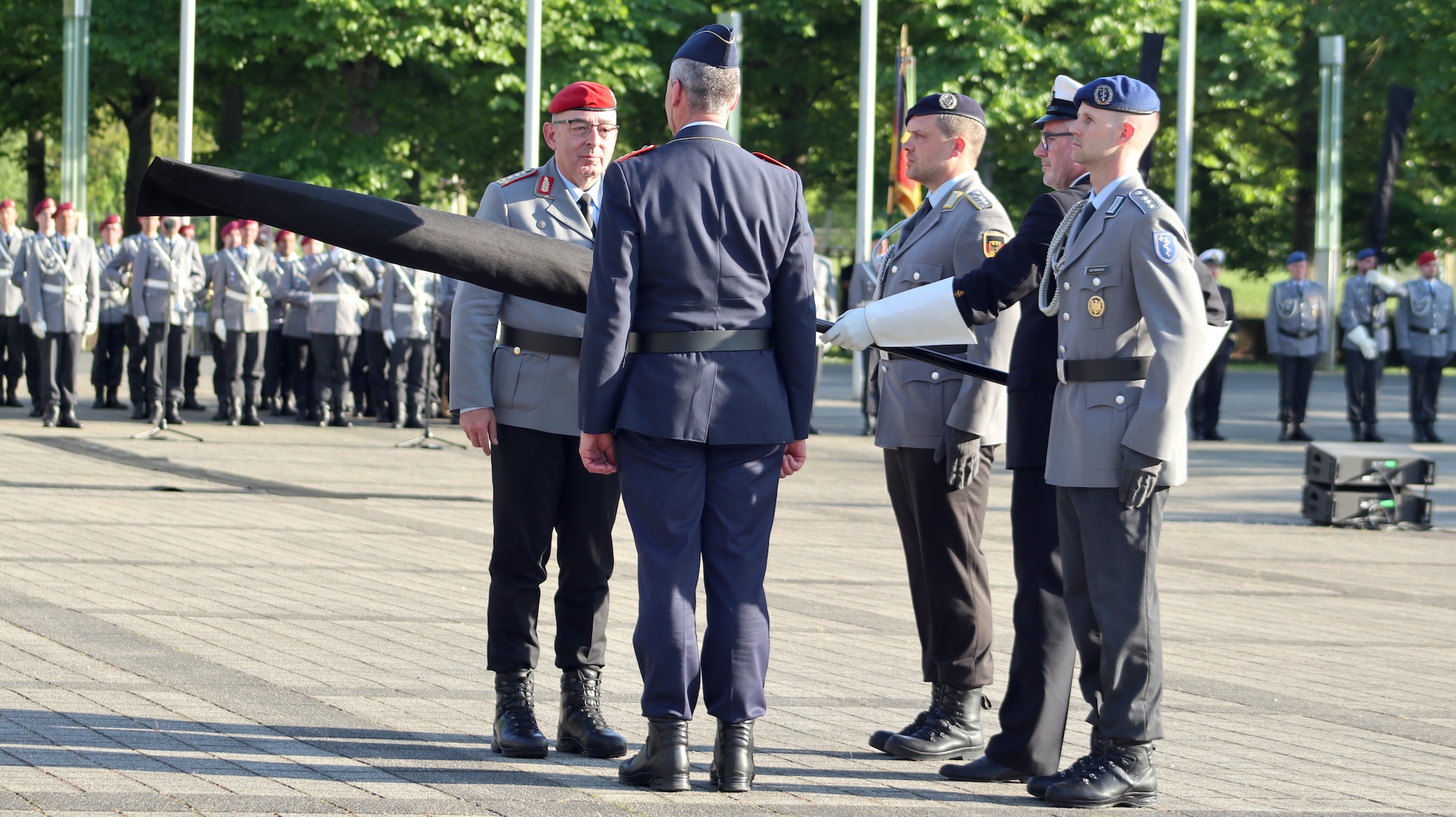 General Breuer (l.) und Generalleutnant Funke (umgedreht) enthüllen die neue Truppenfahne.