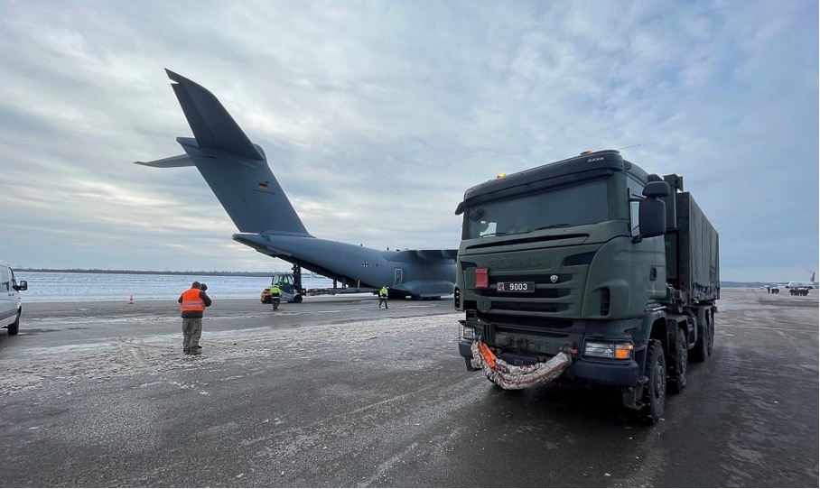 Luxemburger Logistik LKW während der Beladung mit Luftfracht. Im Hintergrund eine deutsche A400M.