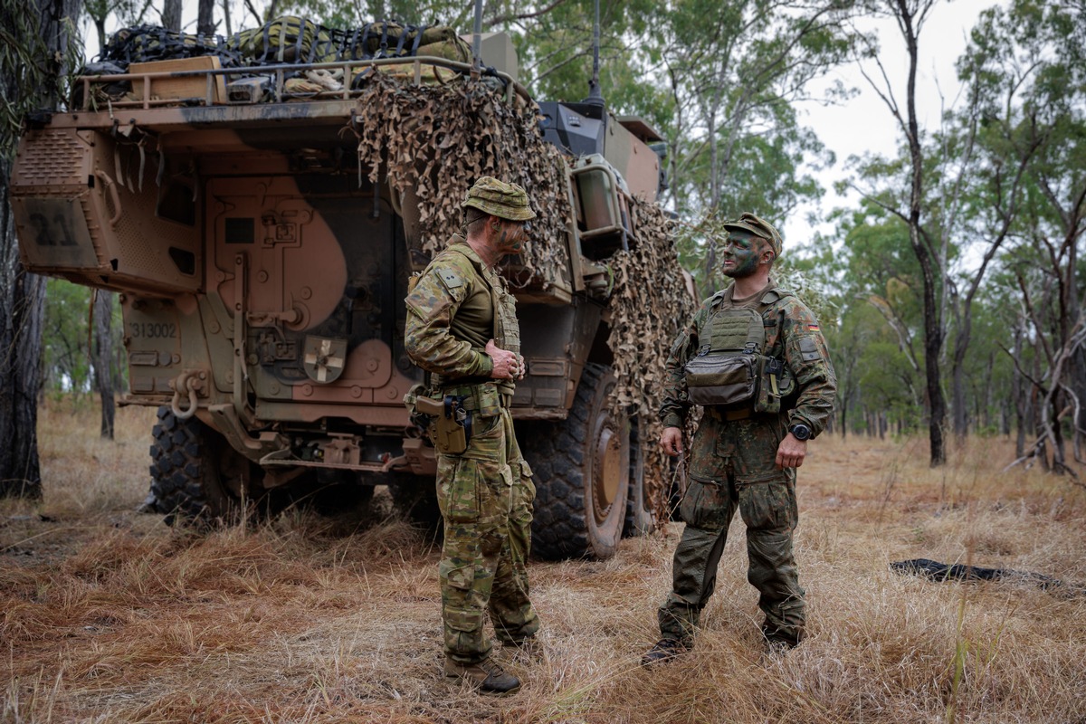 Ein deutscher und ein australischer Soldat bei der Übung Talisman Sabre 25 im Gespräch - da künftig der Boxer als schwerer Waffenträger Infanterie Teil des deutschen Heeres wird, informieren sich Soldaten vom Jägerbataillon 413 über die Erfahrungen der Australier.