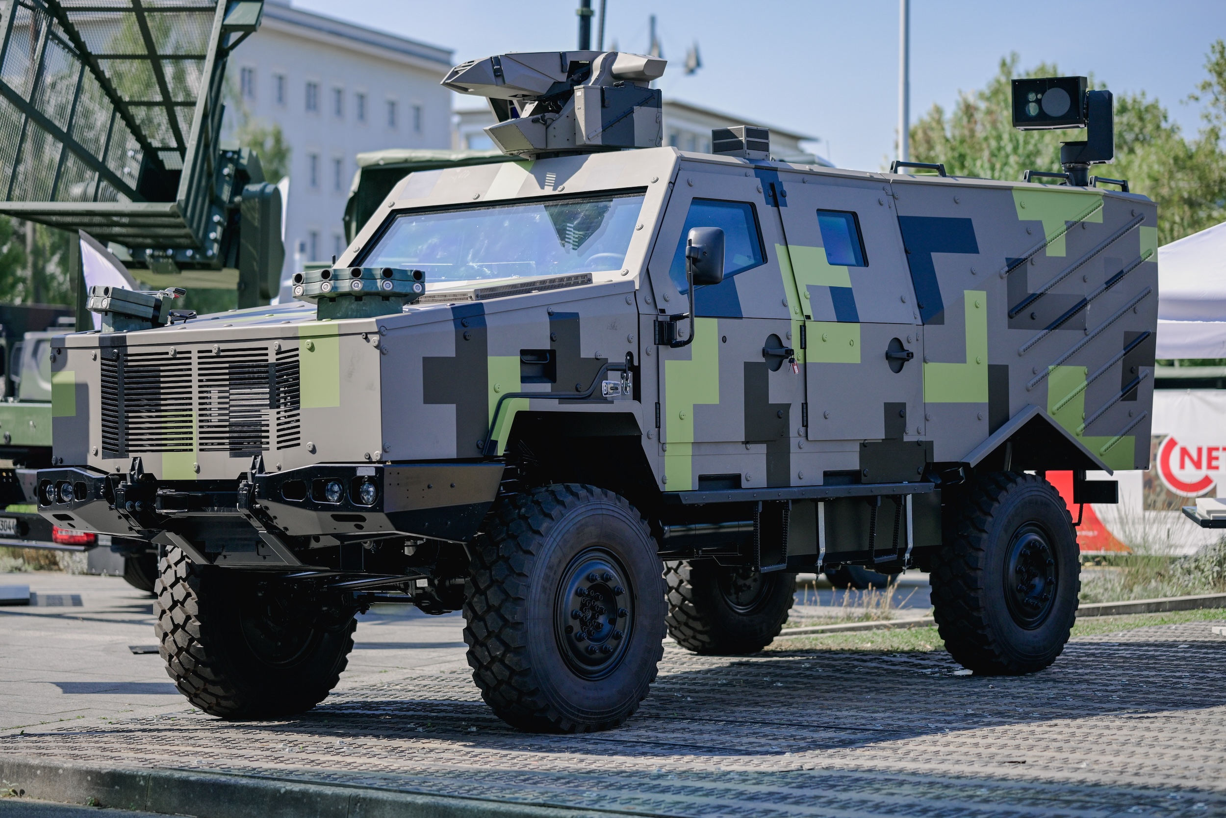 Panzerjäger-Konzept von Rheinmetall, wie auf der RüNet 2024 gezeigt. Gut zu erkennen sind die Waffenstation NATTER, das elektro-optisches Sensorsystem EOS500 sowie auf der Motorhaube zwei Schnellnebelsystem ROSY. Die zwei Werfer für die Panzerabwehrraketen oder alternativ die Loitering Munition sind im Dach eingefahren und daher nicht zu sehen.
