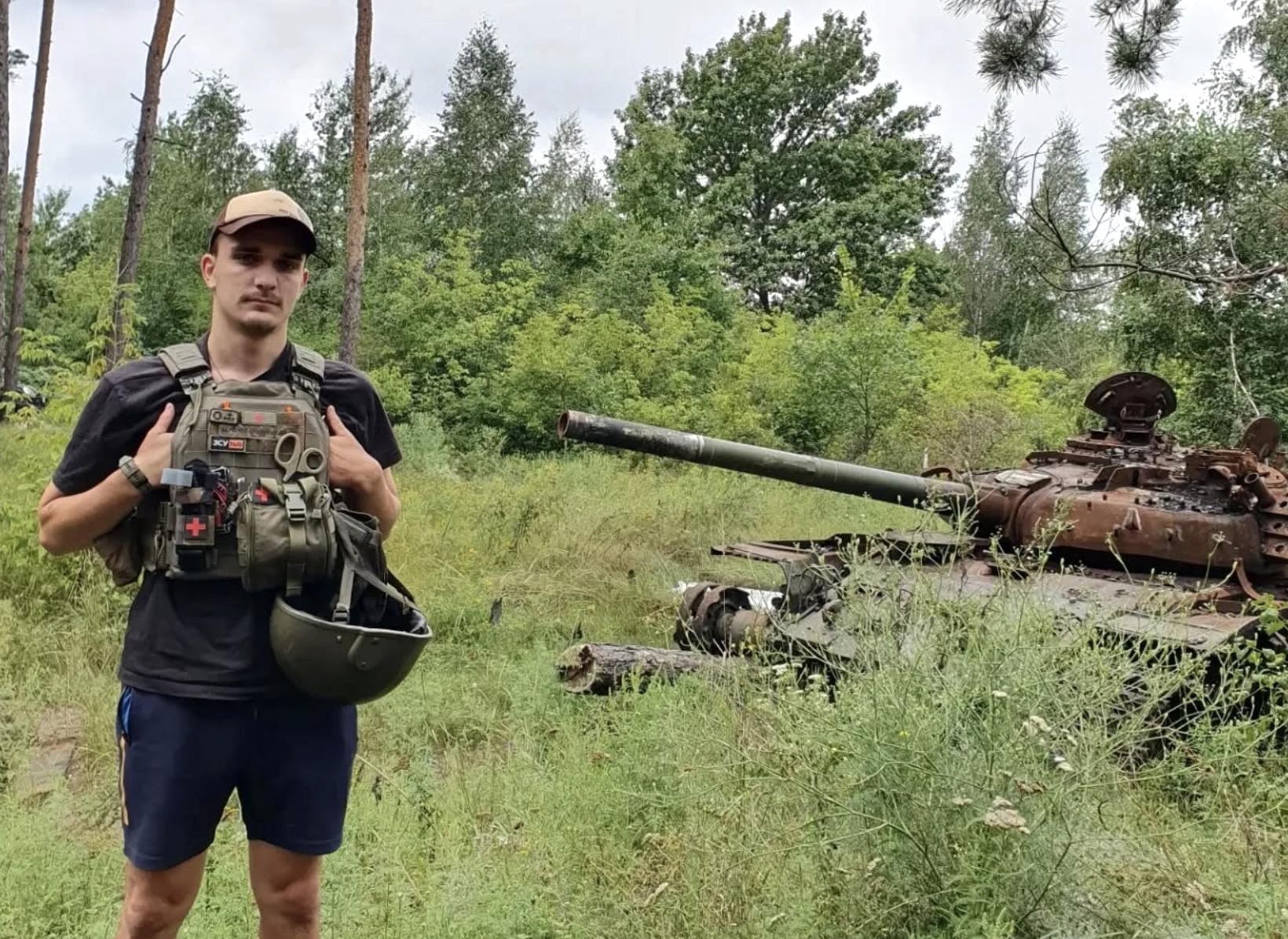 Einblicke in den ukrainischen Alltag – Ruben Mawick steht vor einem ausgebrannten Panzer.
