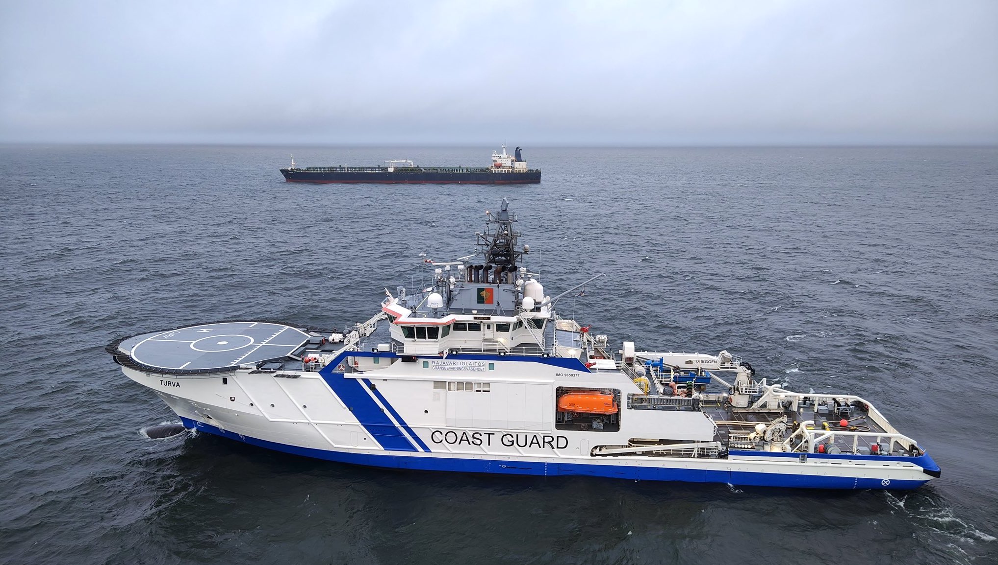 Schiff der finnischen Küstenwache vor dem gestoppten Tanker Eagle S, der vermutlich zur russischen Schattenflotte gehört.