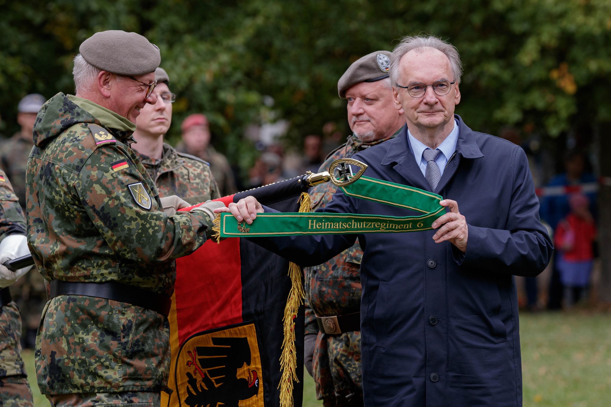 Generalmajor Andreas Henne (l.), Kommandeur der Heimatschutzdivision, und Ministerpräsidenten von Sachsen-Anhalt, Reiner Haseloff halten das Fahnenband.